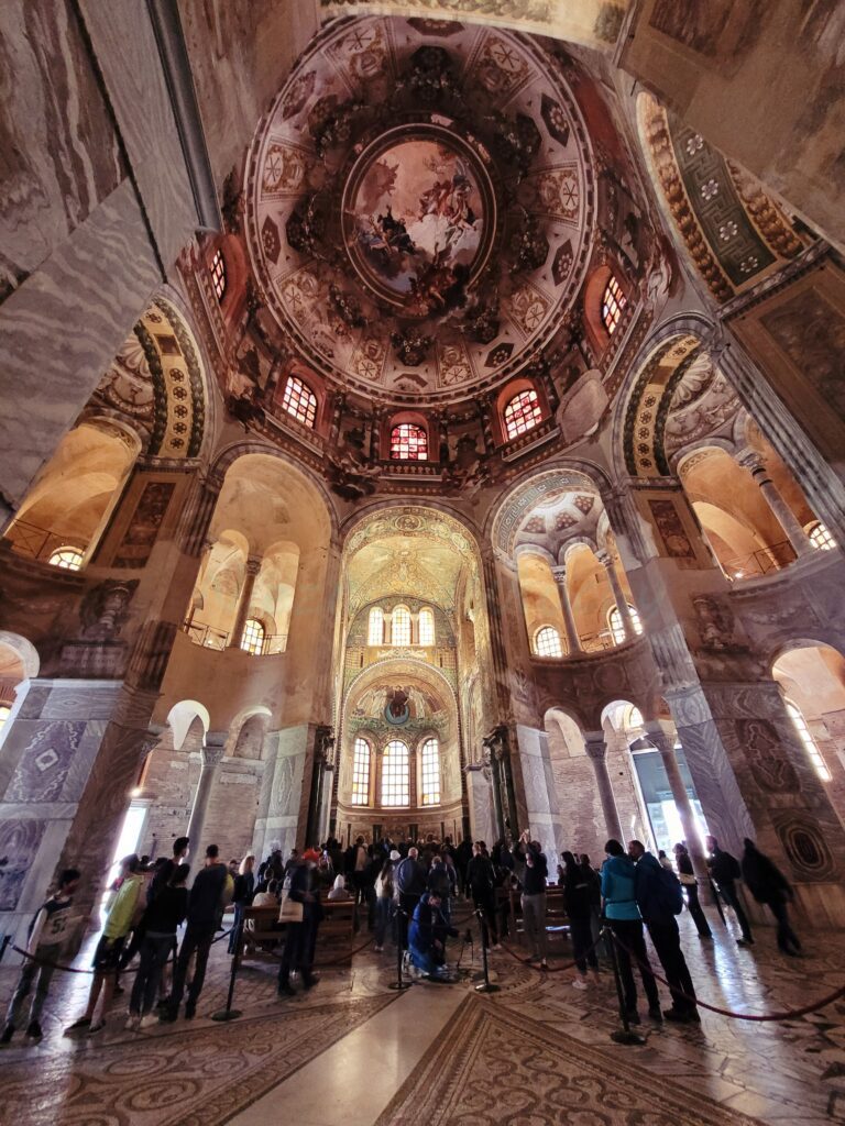 People look at the tall columns decorated with mosaics. inside the church