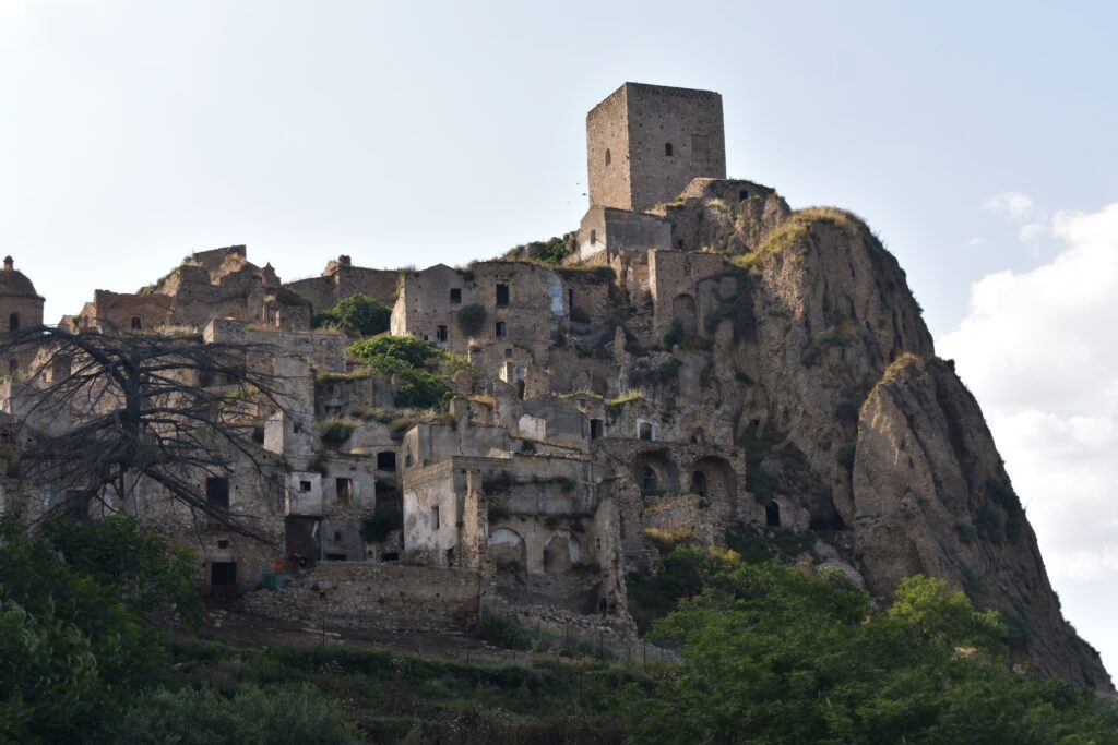 On a grassy hill stand the ruins of a small stone city.