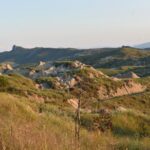 Small clay hills slightly covered with partially dried grass.