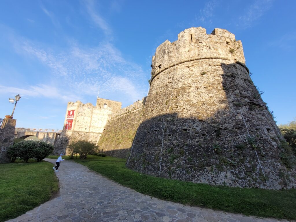 Is Agropoli worth visiting. Stone walls and round tower of Castello Angioino Aragonese in Agropoli, Italy, with a path leading to the historic fortress under a clear blue sky.