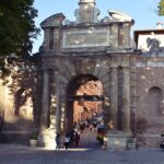 A large brick entrance gate through which people pass.