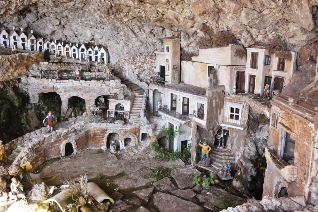 Detailed miniature village display set inside a rock cave at the Abbey of Santa Maria di Pulsano in Gargano, Puglia.