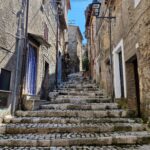 Stone stairway lined with old buildings in a narrow street.
