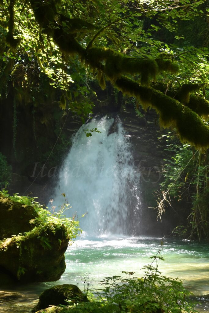 Mały wodospad płynie w otoczeniu drzew koło Trevi Nel lazio