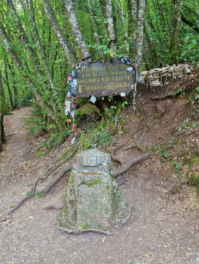 Geograficzny środek Włoch – kamienny słupek i tablica z życzeniami w lesie koło Narni.