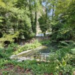 Pathway with visitors walking near Marmore Falls surrounded by lush forest in Umbria, Italy