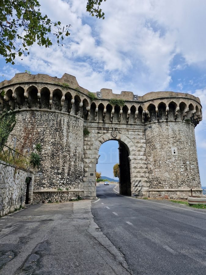 Porta Ternana, a fortified stone gate with two round towers and an arched roadway leading into Narni, Umbria.