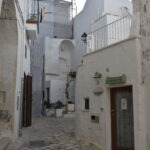 Narrow stone alley with traditional whitewashed houses in the historic center of Polignano a Mare, Puglia