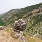 Punkt widokowy nad doliną Valle dell’Orfento w Parku Narodowym Majella – skaliste urwisko z widokiem na zielone wzgórza i wąwóz porośnięty lasem w Abruzji.