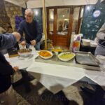 Local vendor serving plates of homemade pasta at a street food stand during Calici nel Borgo Antico in Bisceglie’s old town.