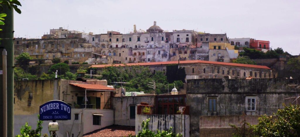 View of Terra Murata, the oldest and highest part of Procida Island, Italy, with historic stone houses and pastel buildings overlooking the sea.
