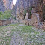Ruins of the Benedictine abbey at Gole di San Martino in Abruzzo, Italy, set between steep rocky cliffs.