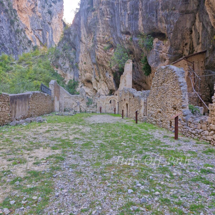 Ruins of the Benedictine abbey at Gole di San Martino in Abruzzo, Italy, set between steep rocky cliffs.