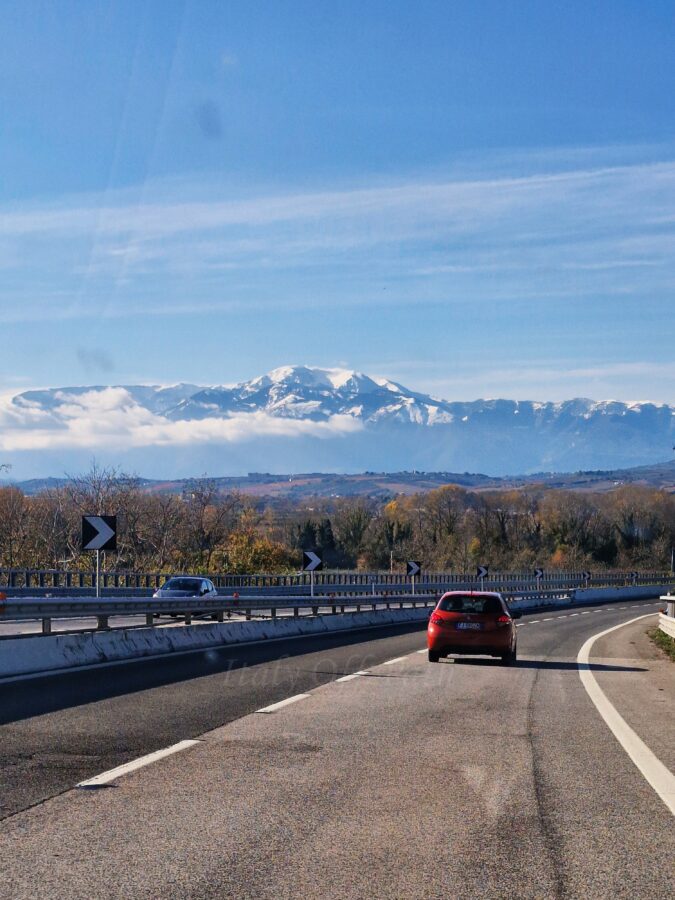 Road in Abruzzo with snow-covered Majella Mountains in the background