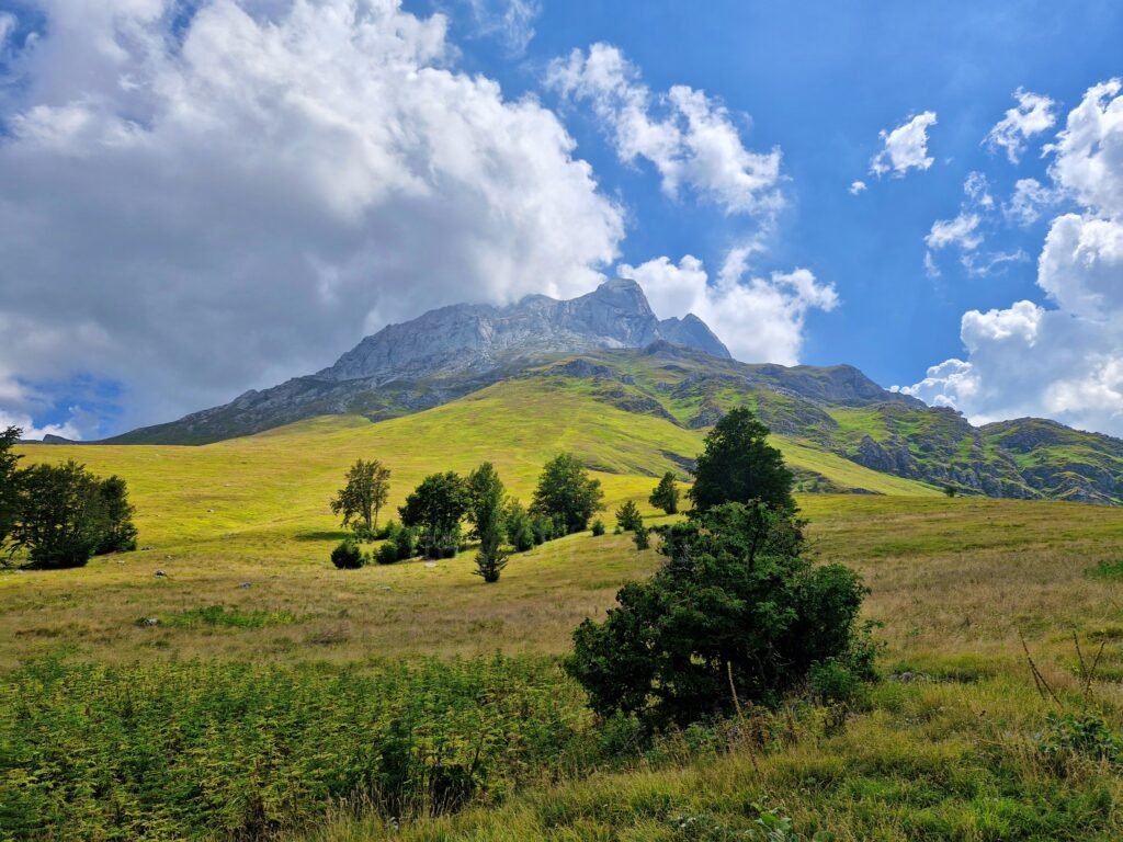 View of Corno Grande peak rising above grassy alpine meadows near Prati di Tivo during an easy hike in Gran Sasso
 in Abruzzo, Italy