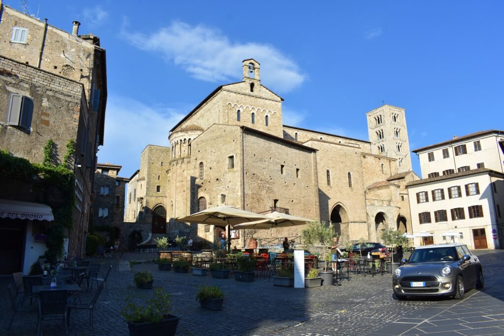 Piazza Innocenzo III and the Romanesque Anagni Cathedral with its bell tower under a blue sky, Lazio, Italy.