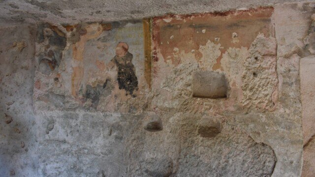 Faded medieval frescoes on the cave wall of a hermitage at Santa Maria di Pulsano in Gargano, Puglia.