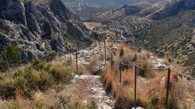 Rocky hiking trail leading down from Santa Maria di Pulsano toward the Gulf of Manfredonia in Gargano, Italy.