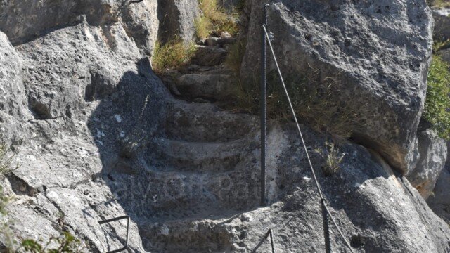 Steep stone steps carved into the limestone cliff leading to the hermitages of Santa Maria di Pulsano, Puglia.