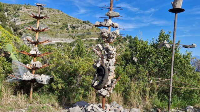 Rustic sculptures made of metal rods, stones, and scrap materials along the Sentiero Apprezzami l'Asino trail in Sapri, Campania, Italy.