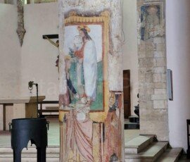 Fresco of Christ and saints painted on a stone column inside a historic church in Narni, Umbria.