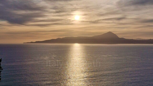 Sunset over the sea with light reflecting on the water, viewed from the skywalk near Maratea, Basilicata.