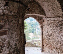 View looking out through the stone archway of Porta San Giovanni onto the valley below in the medieval borgo of Arrone, Umbria.