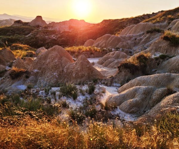 Basilicata badlands The sunset over the Basilicata plateau at Pisici calanchi illuminates the clay hills with a golden glow.