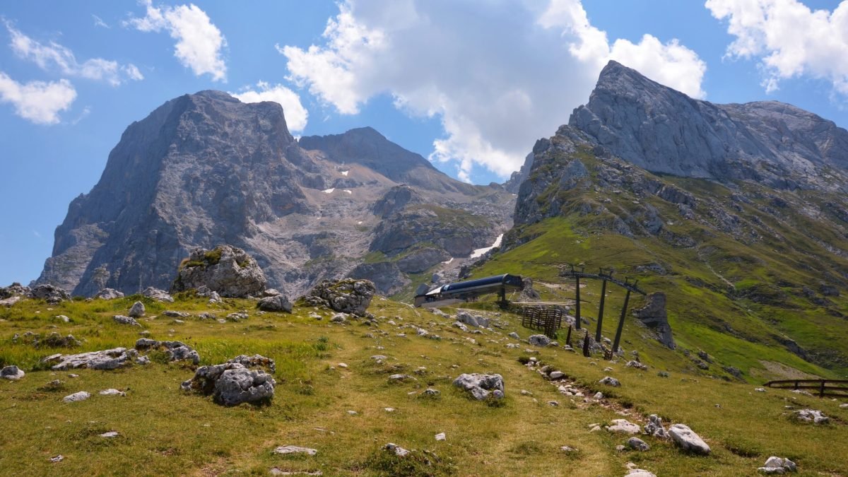 La Madonnina cable car station on the way grassy slope with the rocky peaks while hiking Corno Grande in the Gran Sasso massif, Abruzzo, Italy